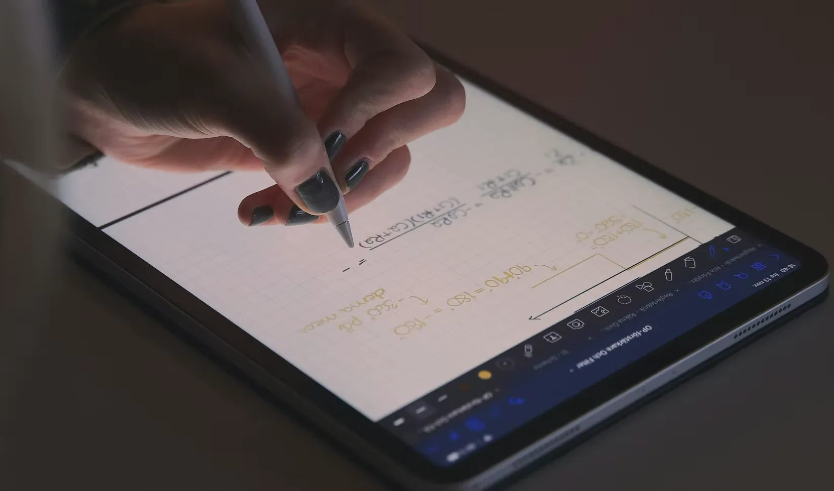 A hand using a stylus on a tablet.